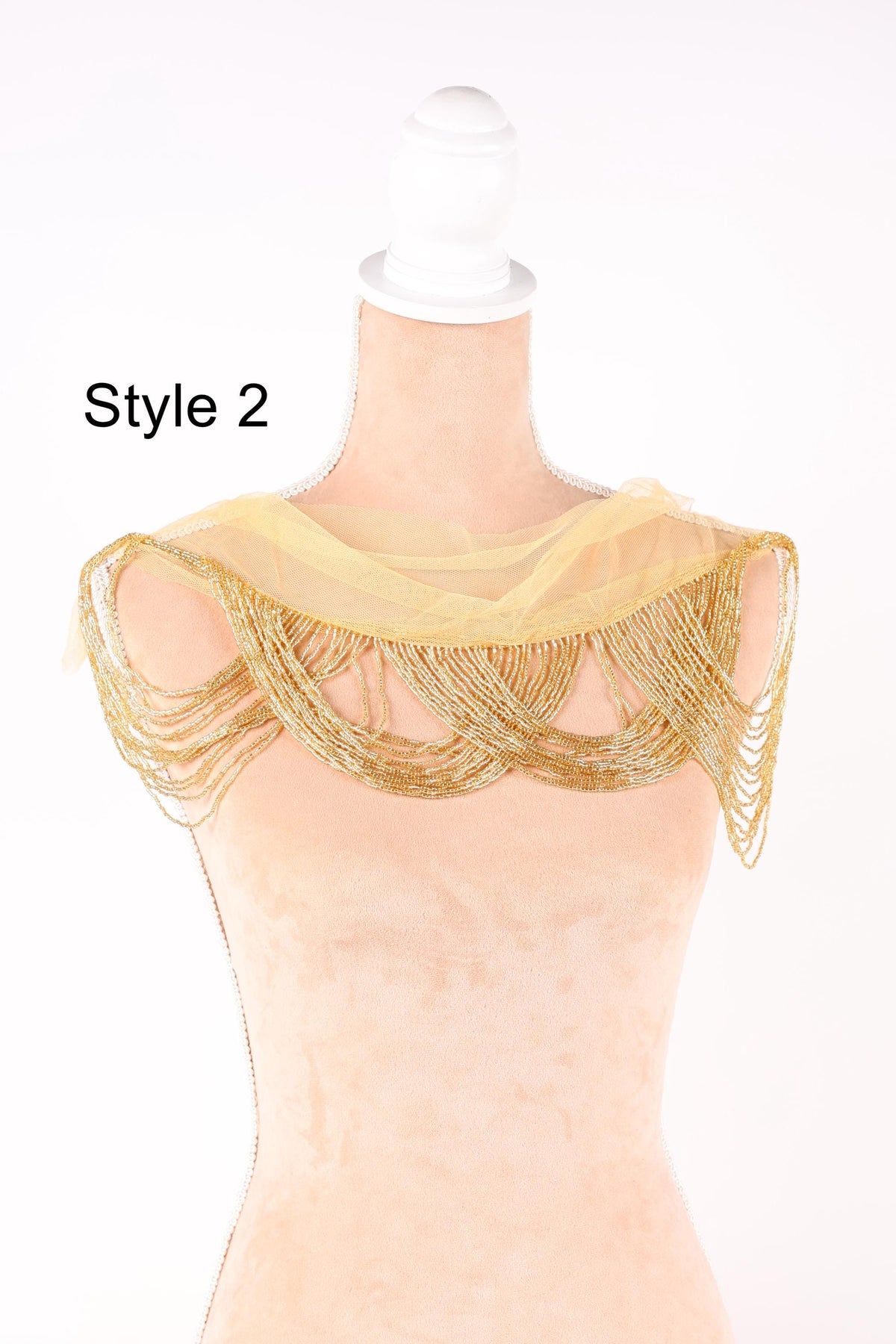 A mannequin wearing a gold and beige shawl with a beaded fringe, labeled as "Style 2".