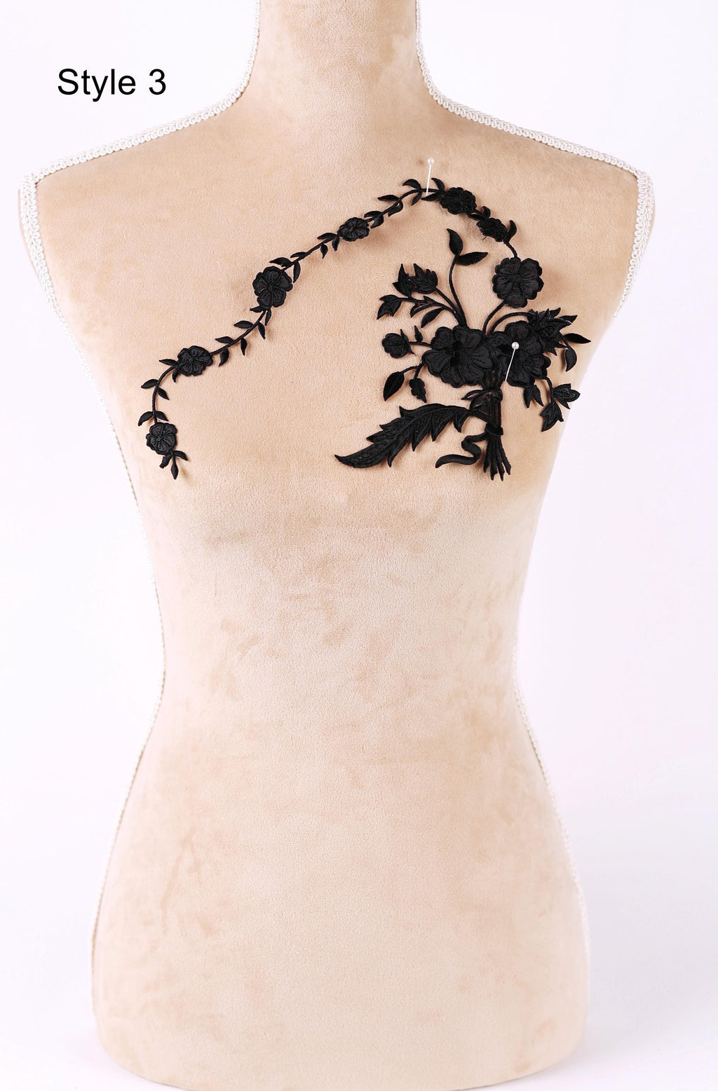 A mannequin with a floral embroidered patch on its shoulder.