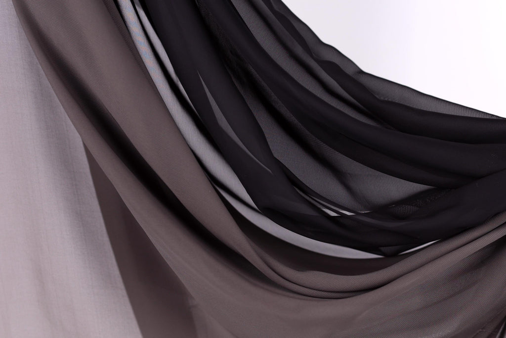 a close-up view of a fabric with a mix of dark and light shades, creating a textured and layered appearance.