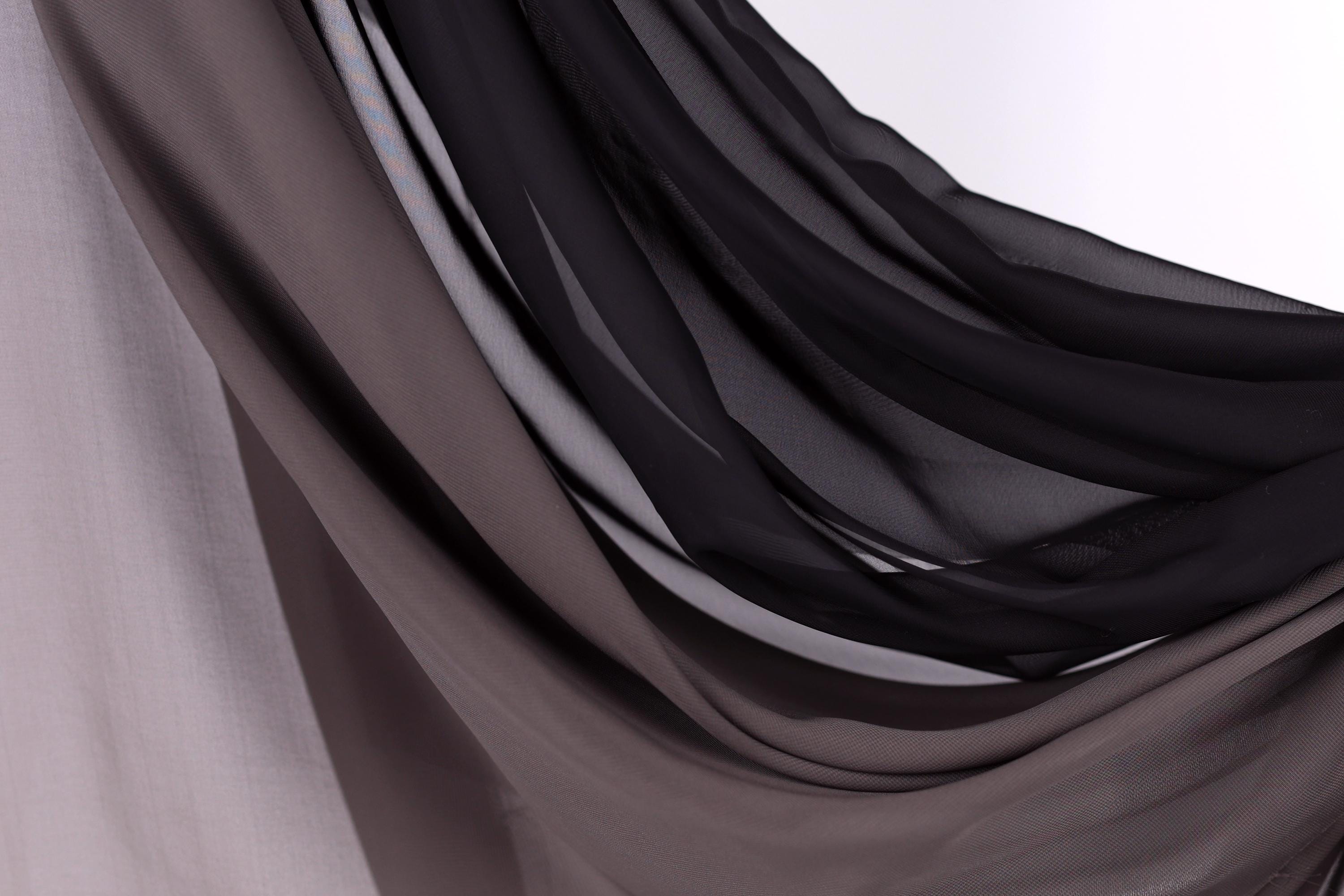 a close-up view of a fabric with a mix of dark and light shades, creating a textured and layered appearance.