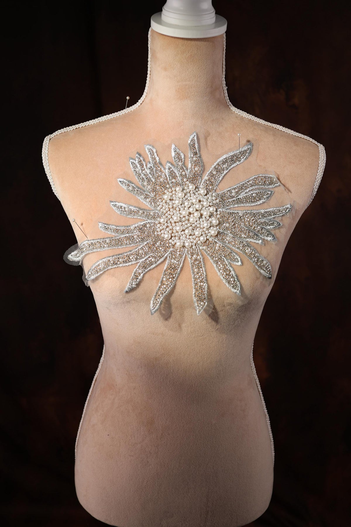 a mannequin with a large crystal flower on it