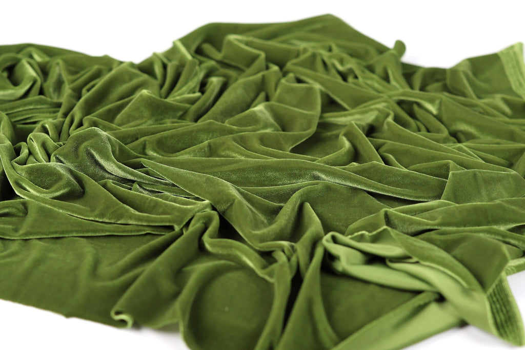a close-up view of a crumpled, green fabric, possibly velvet, with a textured and wrinkled appearance.