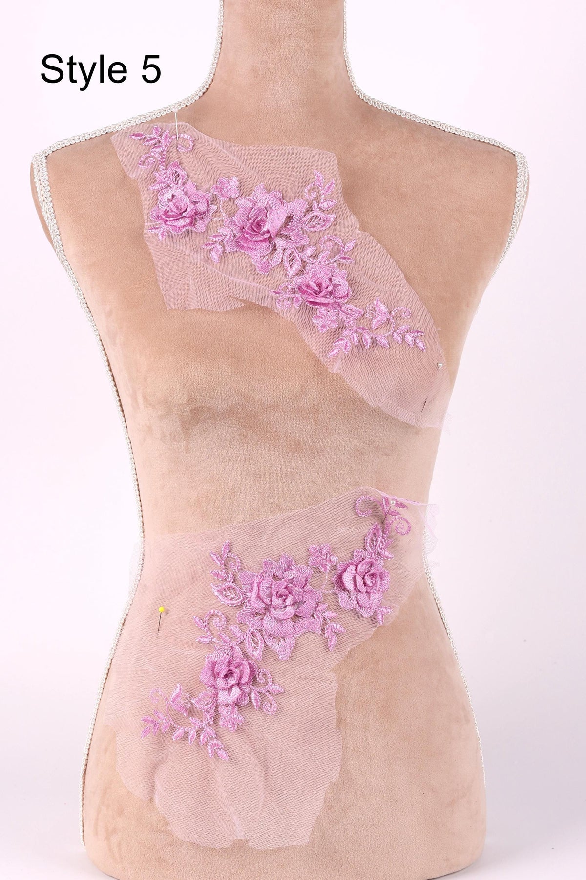 A mannequin with a pink floral embroidered on its torso, featuring a variety of pink flowers and leaves.