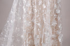 a close-up view of a delicate, white lace dress with a floral pattern.