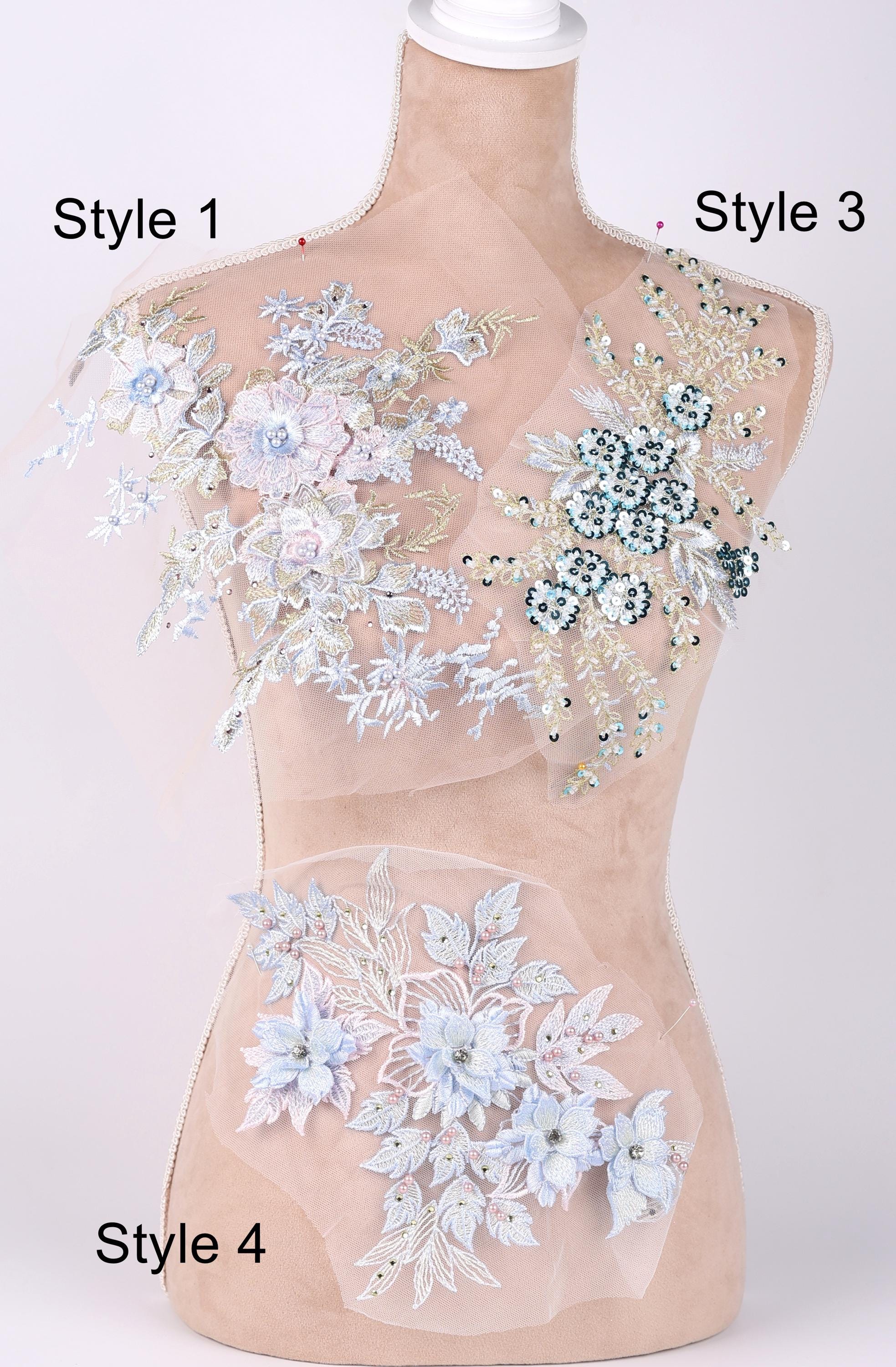 A mannequin with various decorative fabric pieces attached to its torso, including floral and leaf-like patterns in different colors.