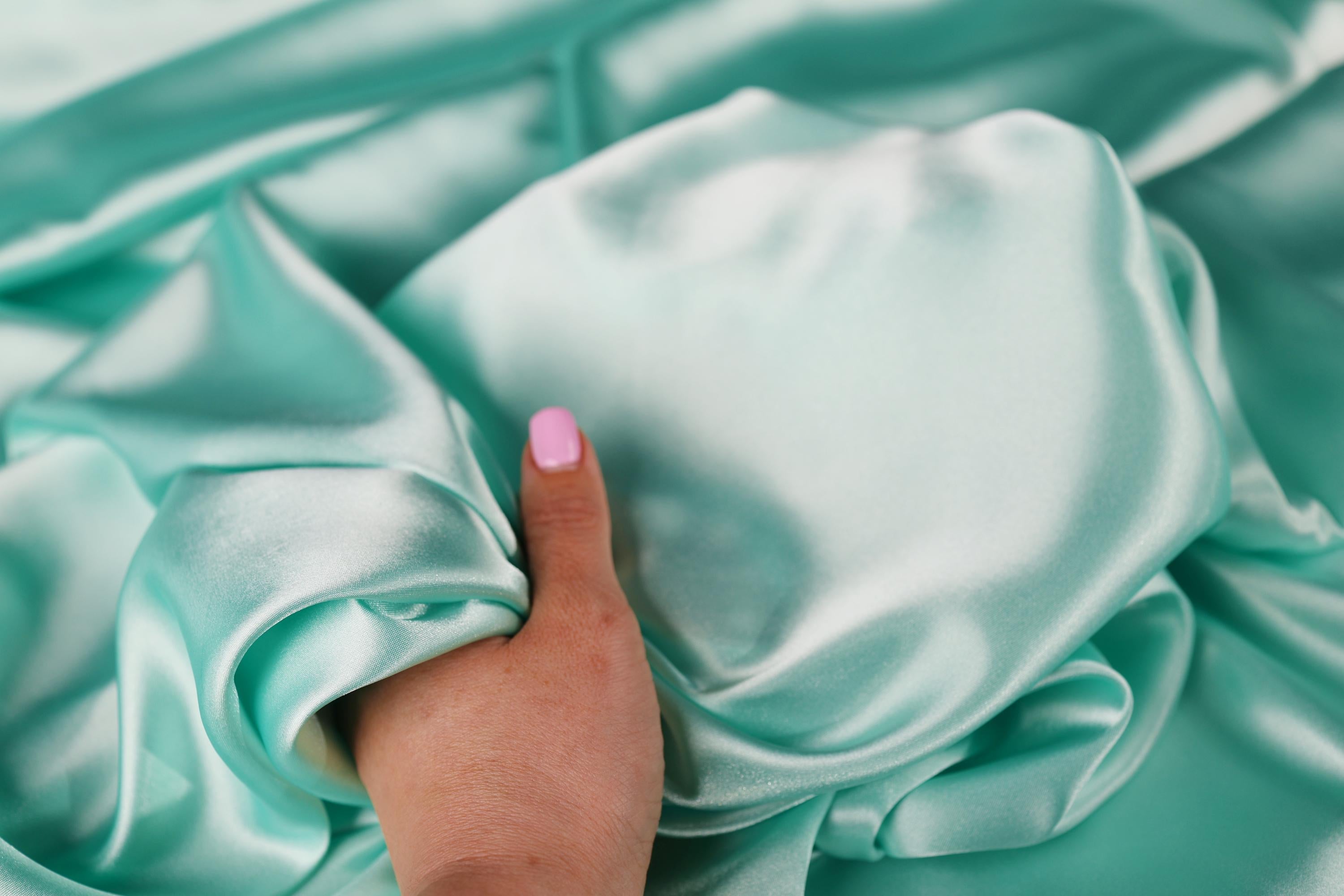a person's hand on a satin material