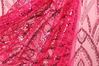 The image is a close-up of a vibrant pink sequin fabric, with a pattern of diagonal lines and small white sequins. The fabric appears to be made of sheer material, giving it a delicate and airy appearance.