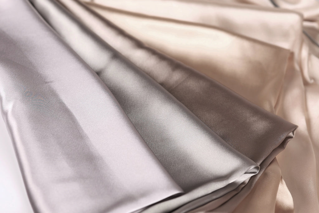 a close-up view of a fabric with a mix of gray and beige colors, folded and arranged in a way that creates a visually appealing composition.