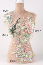 A mannequin with a floral dress on display, featuring various styles of lace and embroidery.