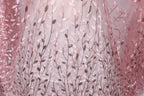 a close-up view of a fabric with a delicate floral pattern, including pink and brown leaves and branches. The fabric appears to be made of a sheer material, giving it a delicate and airy appearance.