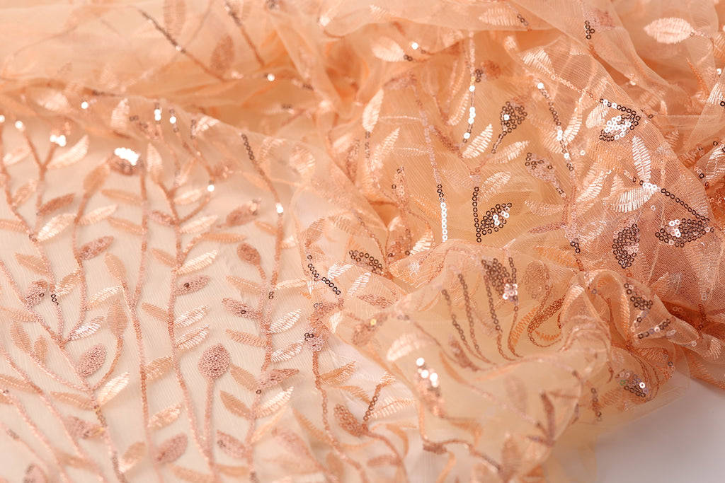 a close-up view of a fabric with a floral pattern and sequin accents, creating a visually appealing and intricate design.