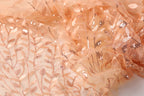 a close-up view of a fabric with a floral pattern and sequin accents, creating a visually appealing and intricate design.
