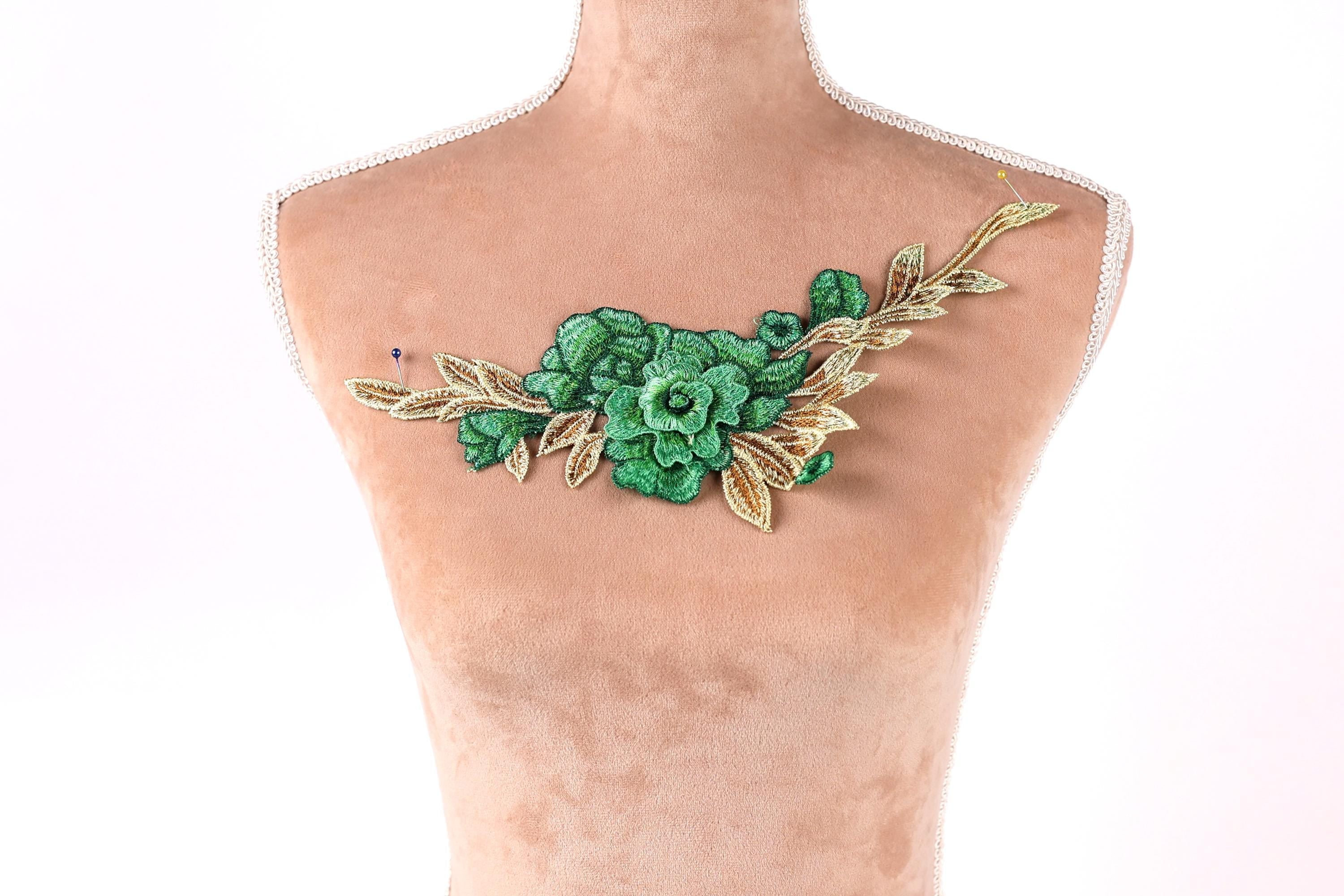 A mannequin with a green floral embroidered on its chest.