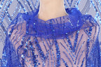 A close-up view of a mannequin wearing a blue sequin dress with a sheer, sheer-like fabric.