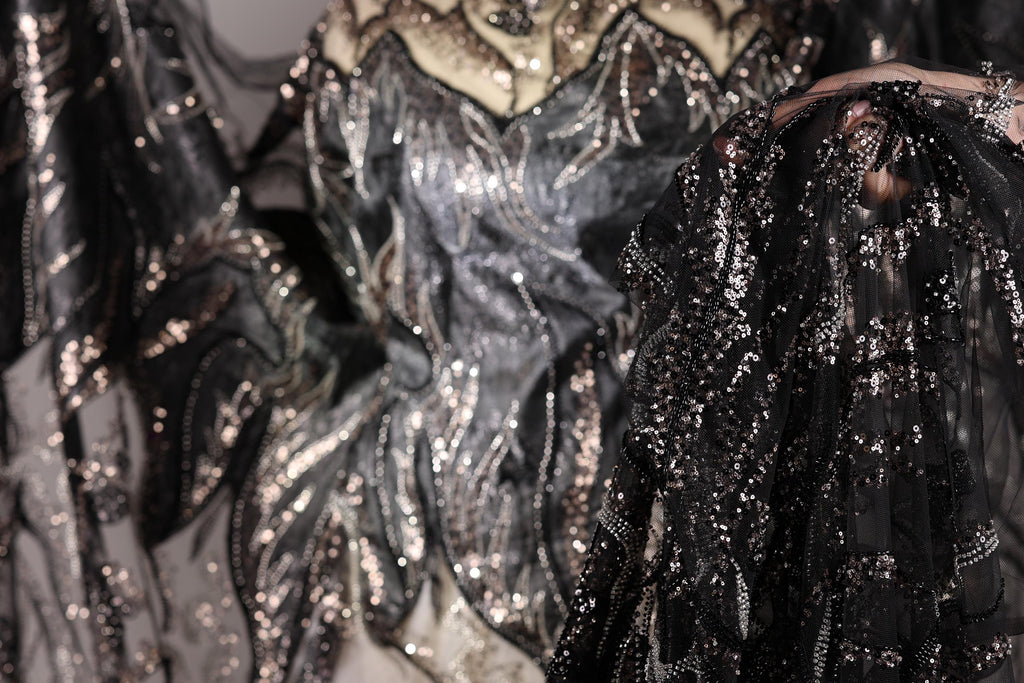 a close-up view of a sequined dress with a black and silver pattern.