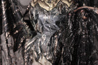 a close-up view of a sequined dress with a black and silver pattern.