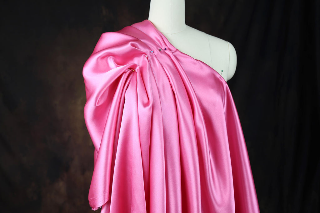 a mannequin dressed in a pink satin dress