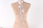 A mannequin with a delicate white lace design on the back, featuring a floral pattern.