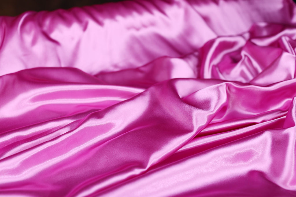a close up of a pink satin material