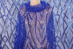 a mannequin wearing a blue sequin shawl or wrap. The sequin pattern is intricate and eye-catching, with a vibrant blue color that stands out against the background.