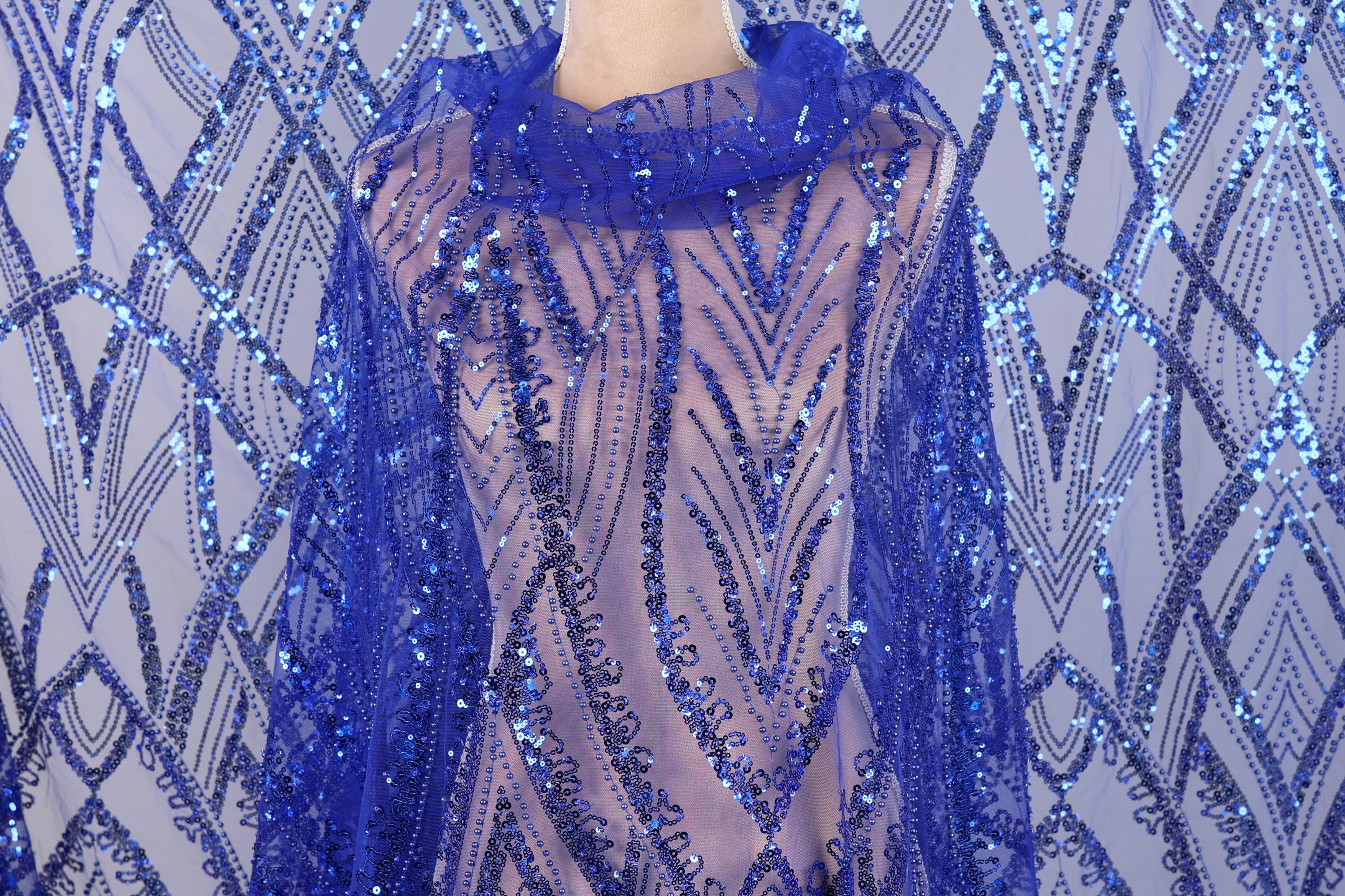 a mannequin wearing a blue sequin shawl or wrap. The sequin pattern is intricate and eye-catching, with a vibrant blue color that stands out against the background.