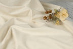 a close-up of a white fabric with a small bouquet of dried flowers resting on it.