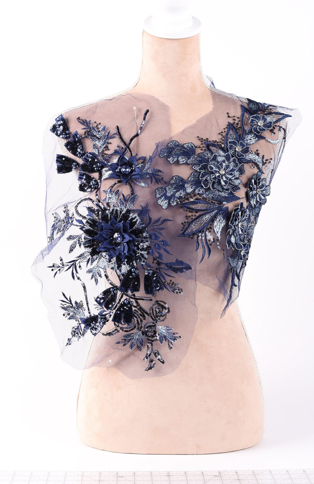 A mannequin wearing a dress with a floral pattern on the bodice and sleeves.