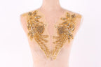 a mannequin with two gold embellishments on its bust, including flowers and leaves.