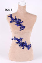 A mannequin wearing a beige dress with a decorative blue lace or sequin piece on the bust area.