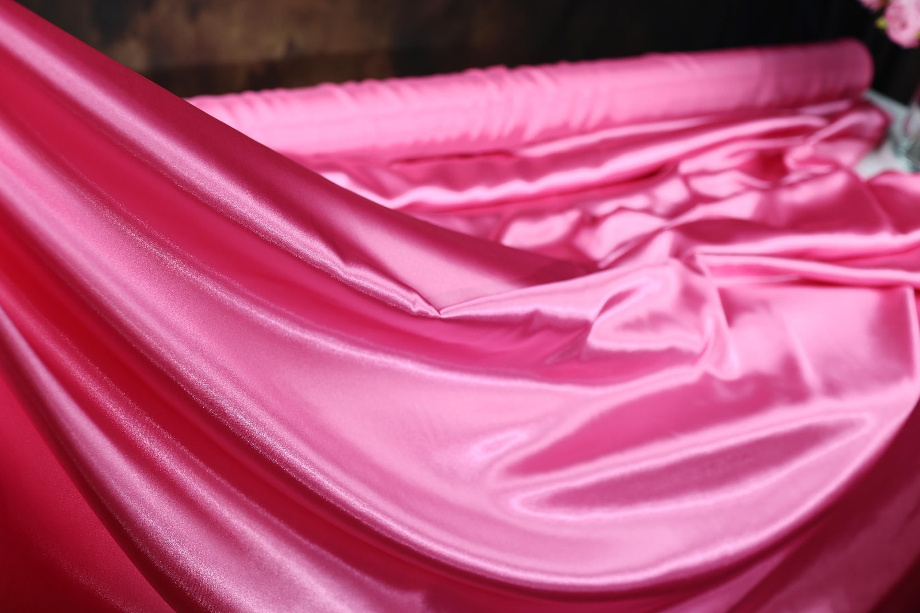 a close up of a pink sheet on a bed