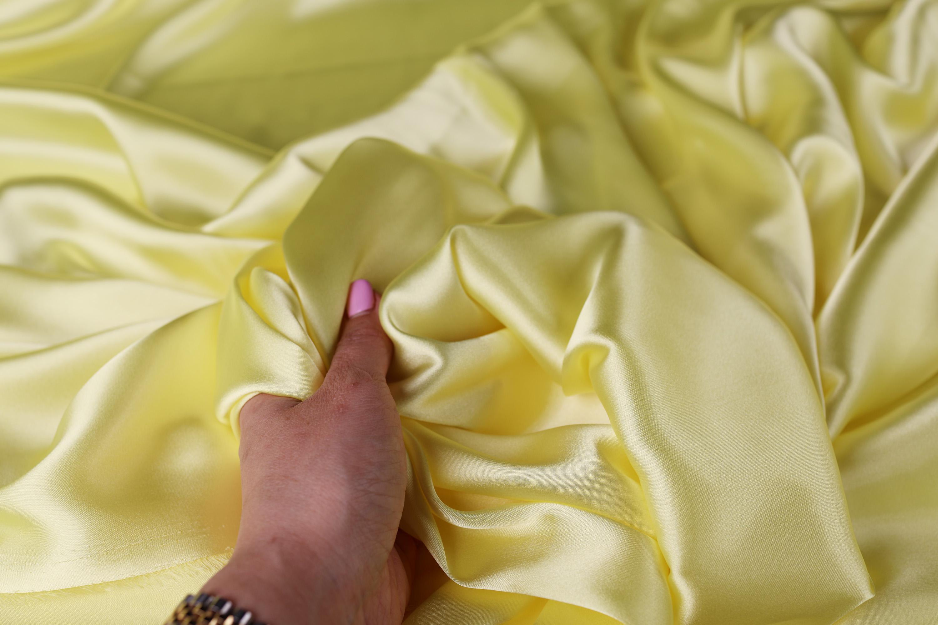 a person&#39;s hand on a yellow fabric