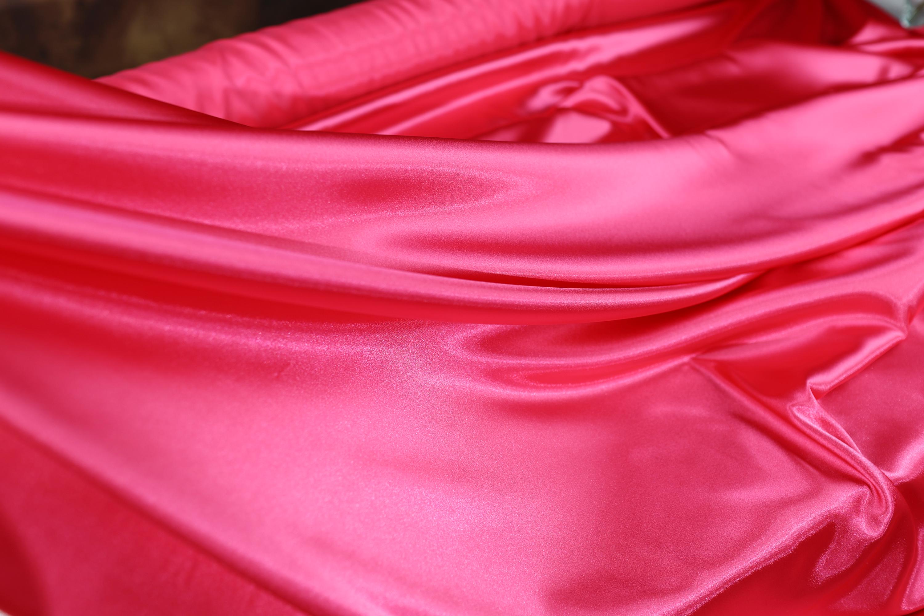 a close up of a pink satin material