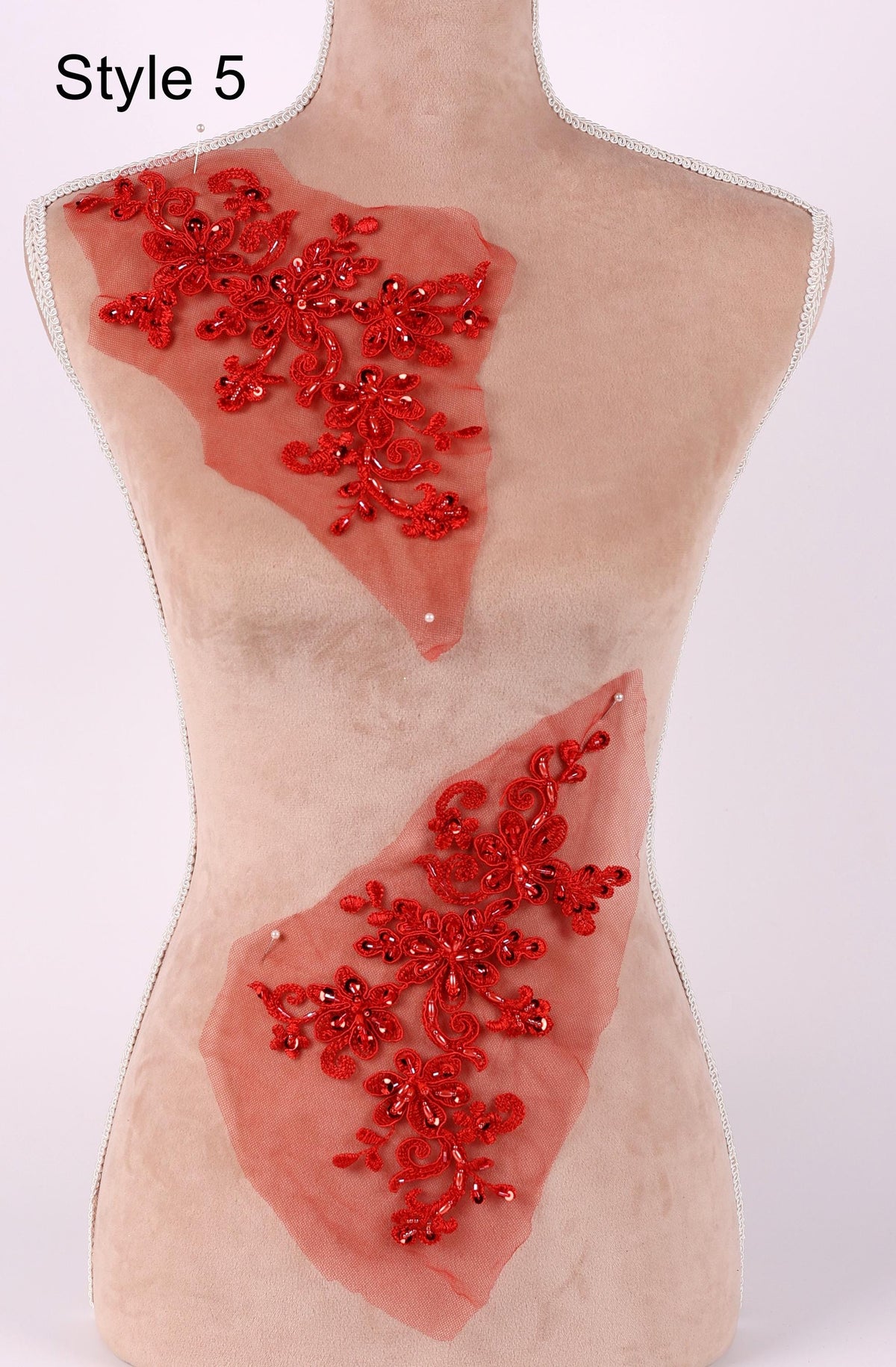 A mannequin with red floral embellishments on its torso.