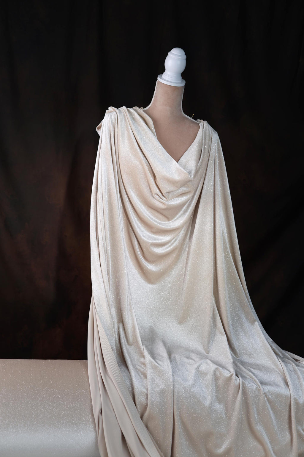a mannequin dressed in a white draped dress