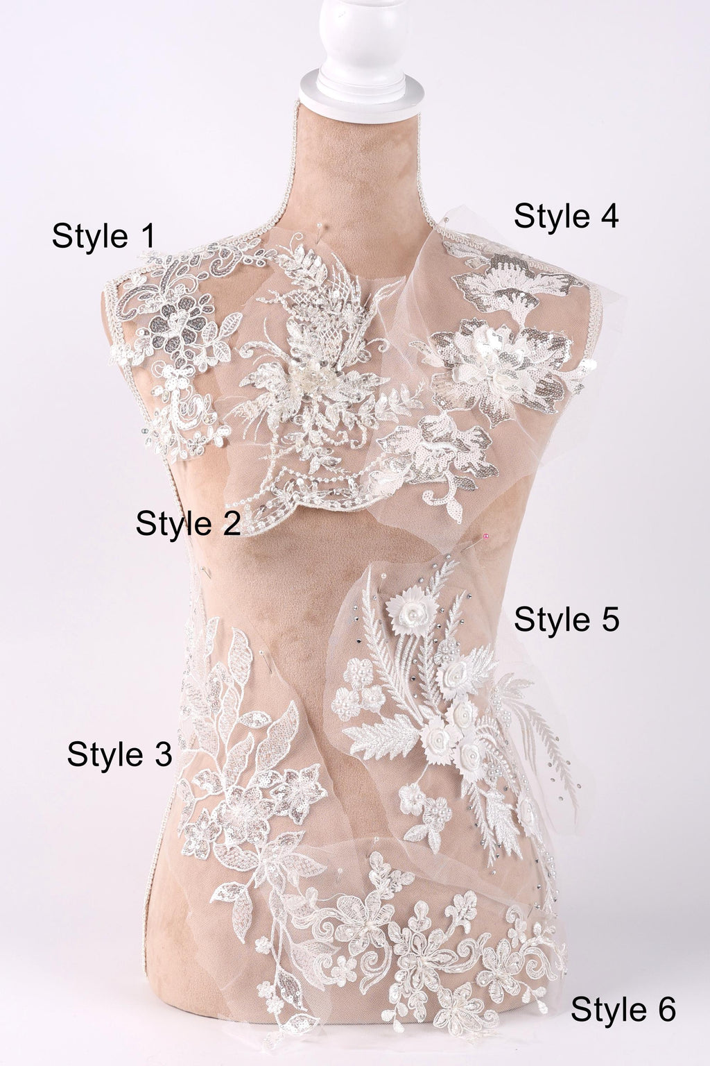 A mannequin with a white lace bodice and various decorative floral and lace embellishments displayed on it.