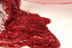 a close-up view of a red sequin fabric, with its intricate patterns and textures visible.