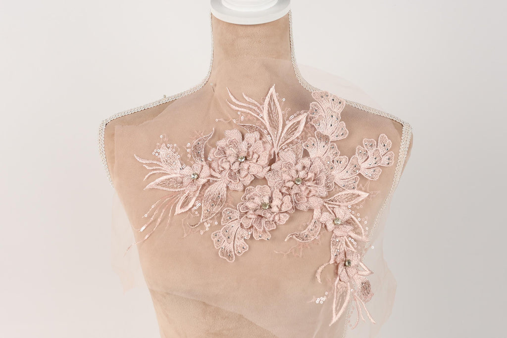 A mannequin with a delicate, floral-patterned fabric draped over it.