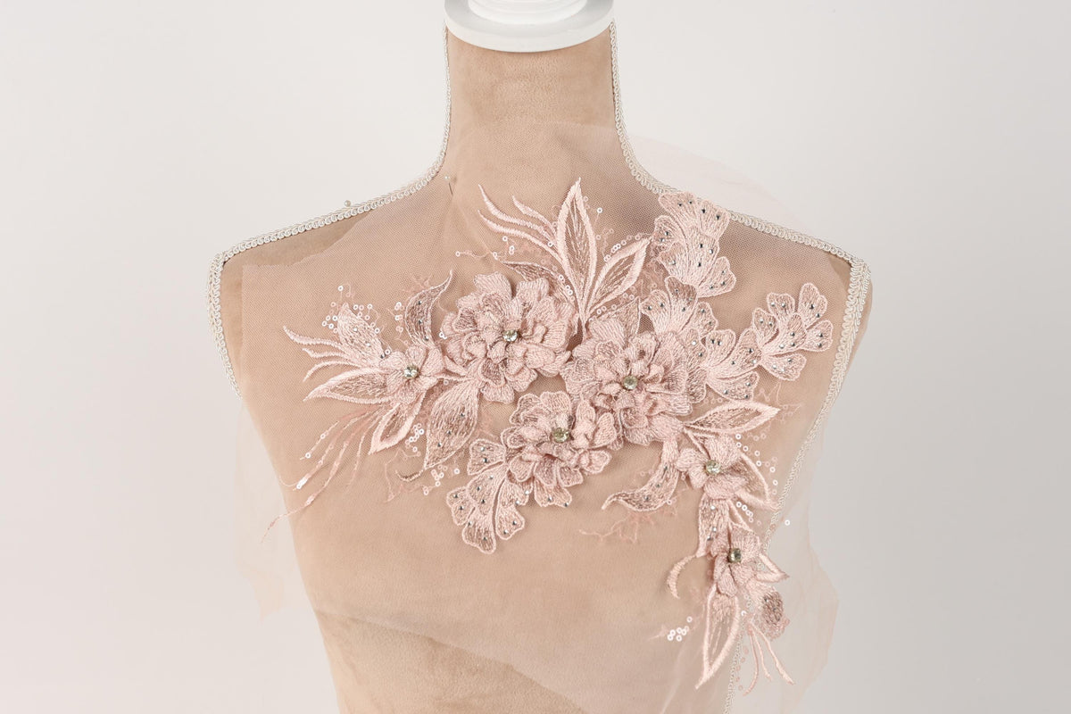 A mannequin with a delicate, floral-patterned fabric draped over it.