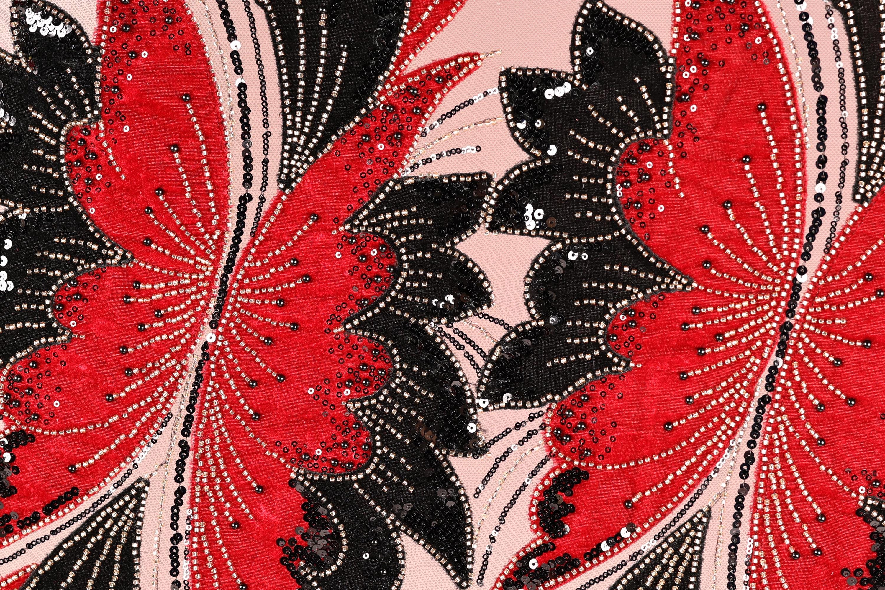 a close-up view of a fabric with a striking pattern of red and black butterflies. The butterflies are intricately designed with sequins and beads, creating a visually captivating and detailed design.