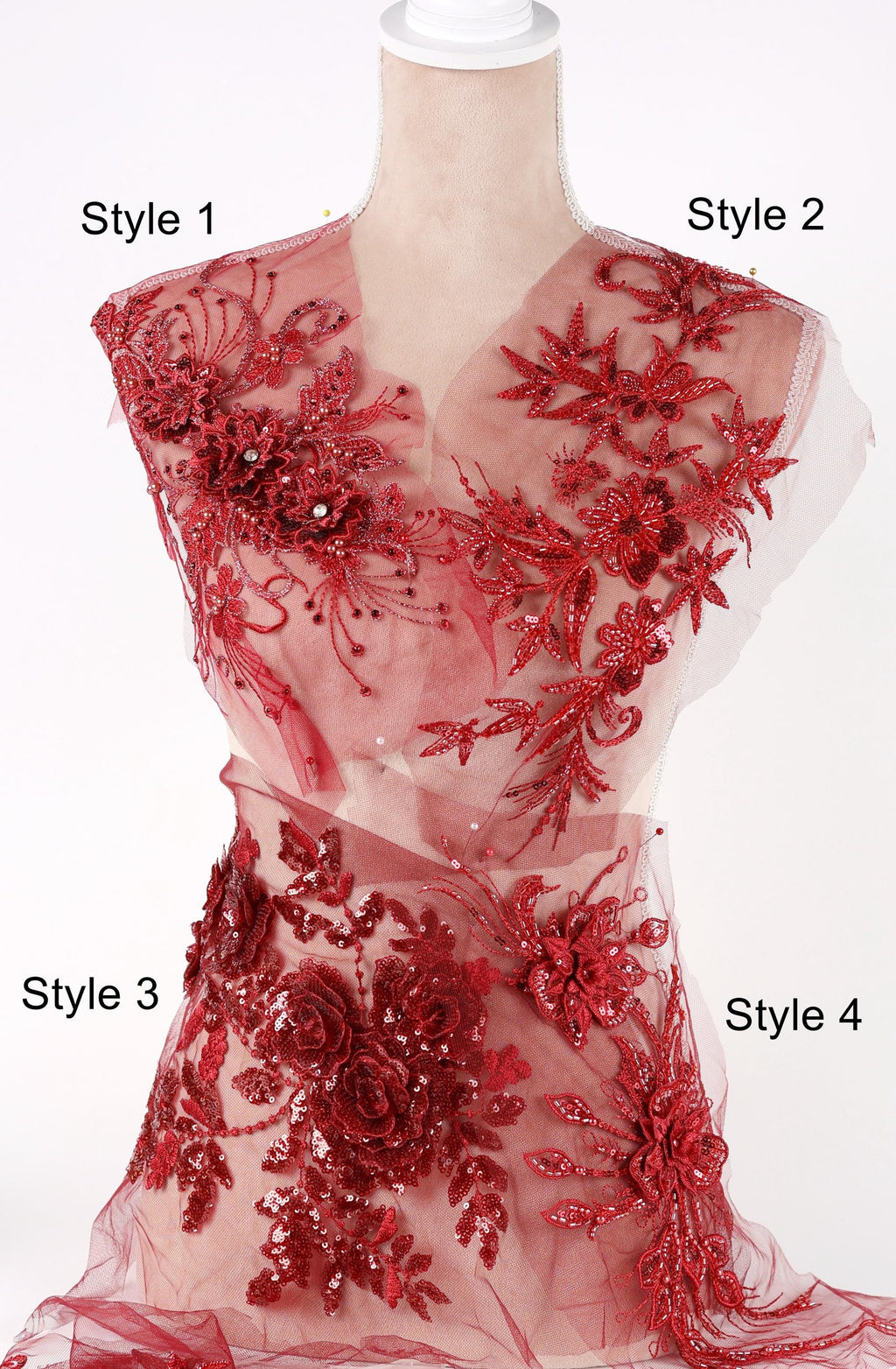 A mannequin wearing a red dress with intricate floral embroidery and sequin details.