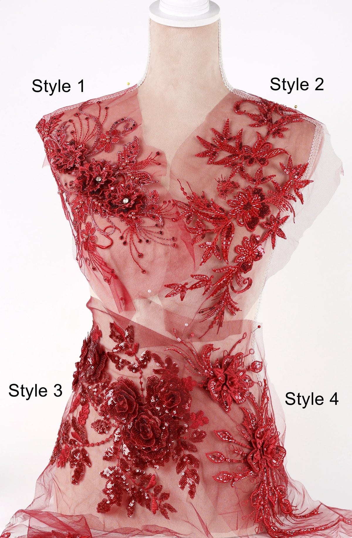 A mannequin wearing a red dress with intricate floral embroidery and sequin details.