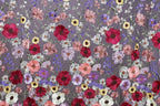 a vibrant and colorful floral pattern with a variety of flowers in shades of red, pink, white, and purple. The flowers are intricately embroidered or stitched onto a fabric or surface, creating a visually striking and detailed design.