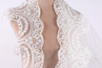 A close-up view of a delicate, lace-like fabric, possibly a wedding veil or a similar decorative piece.