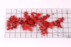 a close-up view of a red sequin flower pattern on a ruler, indicating the size of the pattern.