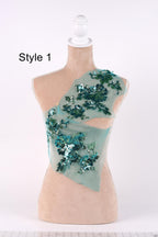 A mannequin with a light-colored body and a light-colored headdress adorned with green sequins.