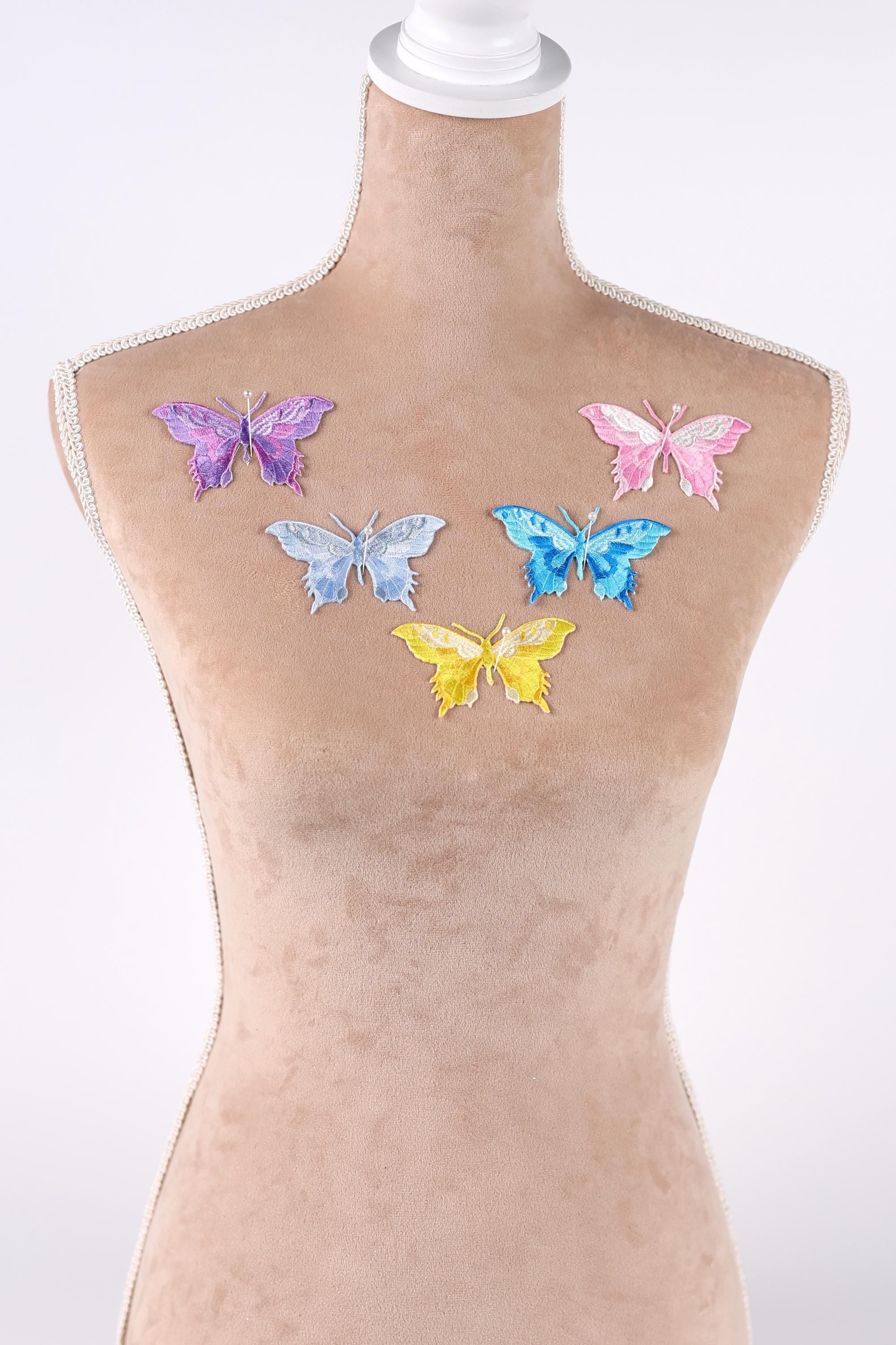 A mannequin torso with colorful butterfly patches on it.
