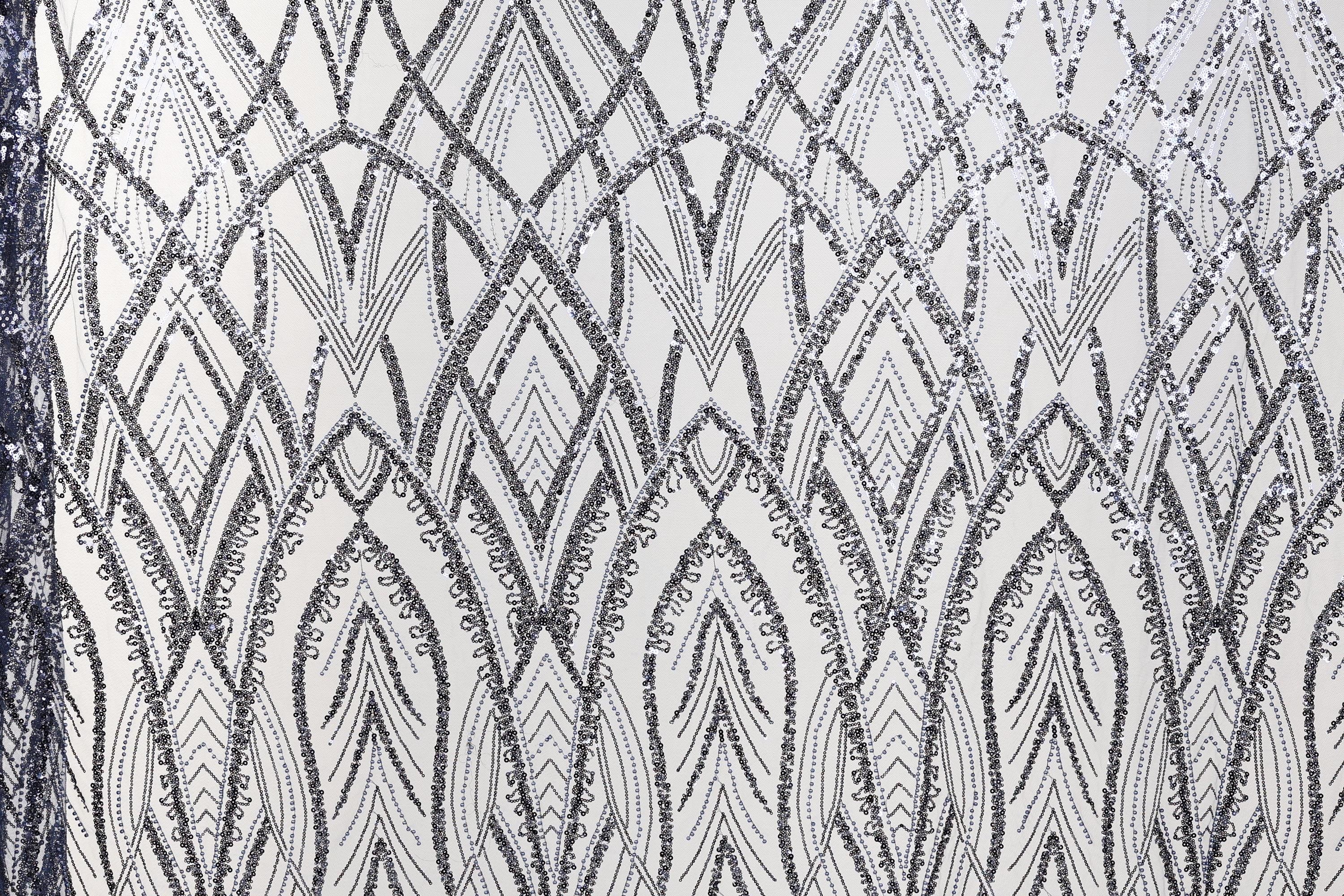 a close-up view of a fabric with a repeating pattern of diamond shapes in shades of black and white. The pattern is intricate and detailed, with the diamonds arranged in a diagonal line across the fabric. The overall appearance of the fabric suggests it could be used for decorative purposes or as a textile material.