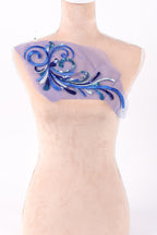 a piece of fabric with a blue and purple floral design, including a blue and purple flower and a blue and purple leaf.