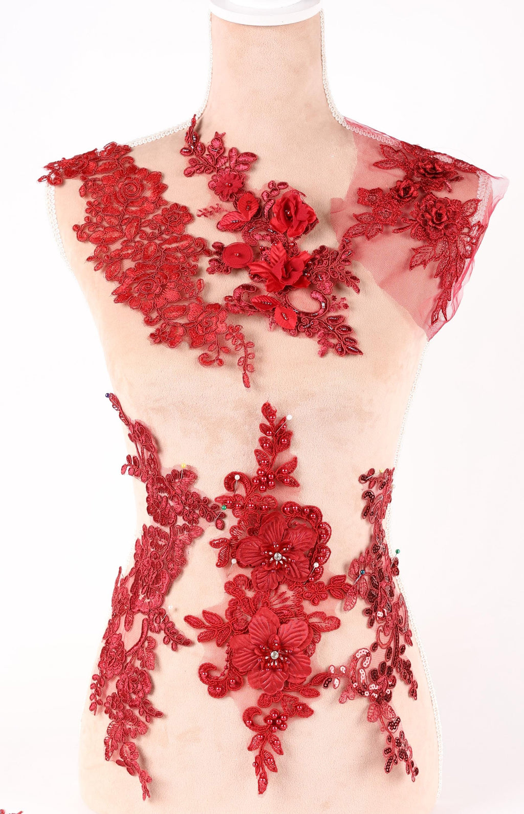 A mannequin wearing a dress with red floral and lace details.