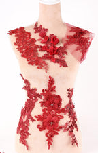 A mannequin wearing a dress with red floral and lace details.